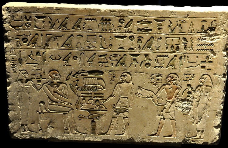 A funerary stela showing the deceased man seated surrounded by his standing family.
