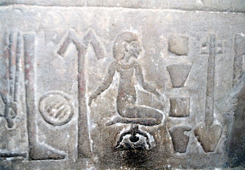 Hieroglyph of woman giving birth, blackened by women touching it with their fingers in hope it will help them get pregnant