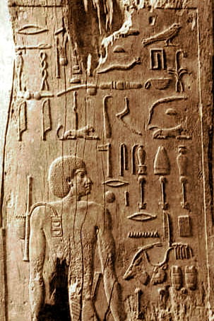 Wooden panel of Hesy-Ra carrying a scribal kit on his shoulder.