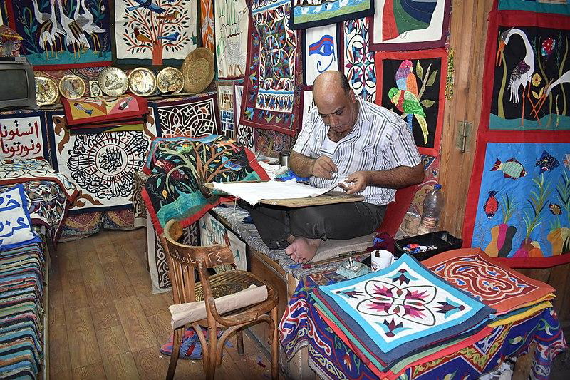 Artisan at work in his shop that doubles as a showroom, via Wikipedia