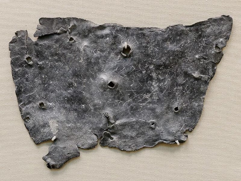 A curse tablet with nail holes, via Wikimedia