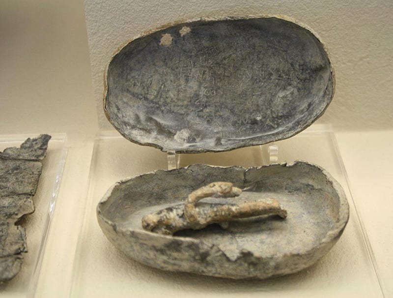 A voodoo figurine in a coffin, via Wikimedia