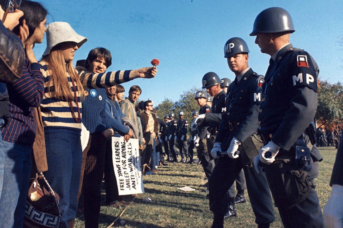 female protester offer flower police 1967