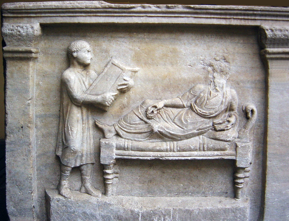 Sarcophagus of Valerius Petronianus showing his slave holding a writing tablet, c. 4th century CE. Source: Archaeological Museum in Milan