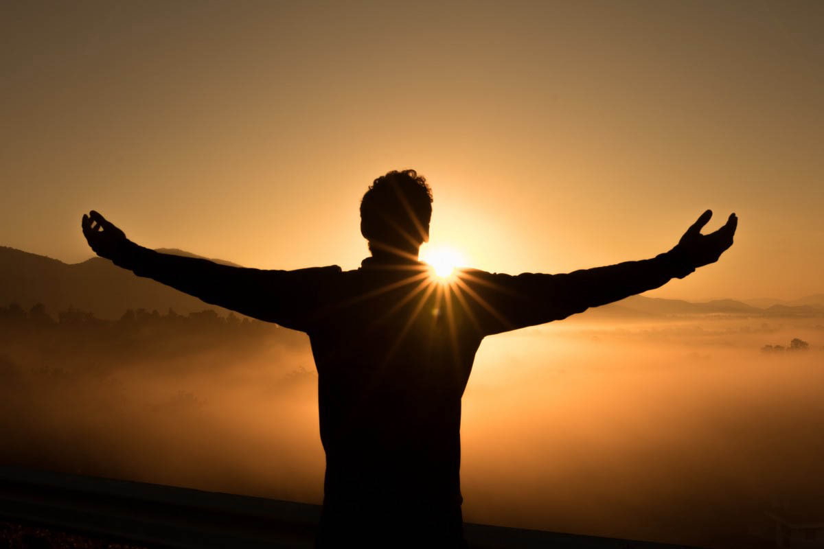 man open arms sunset