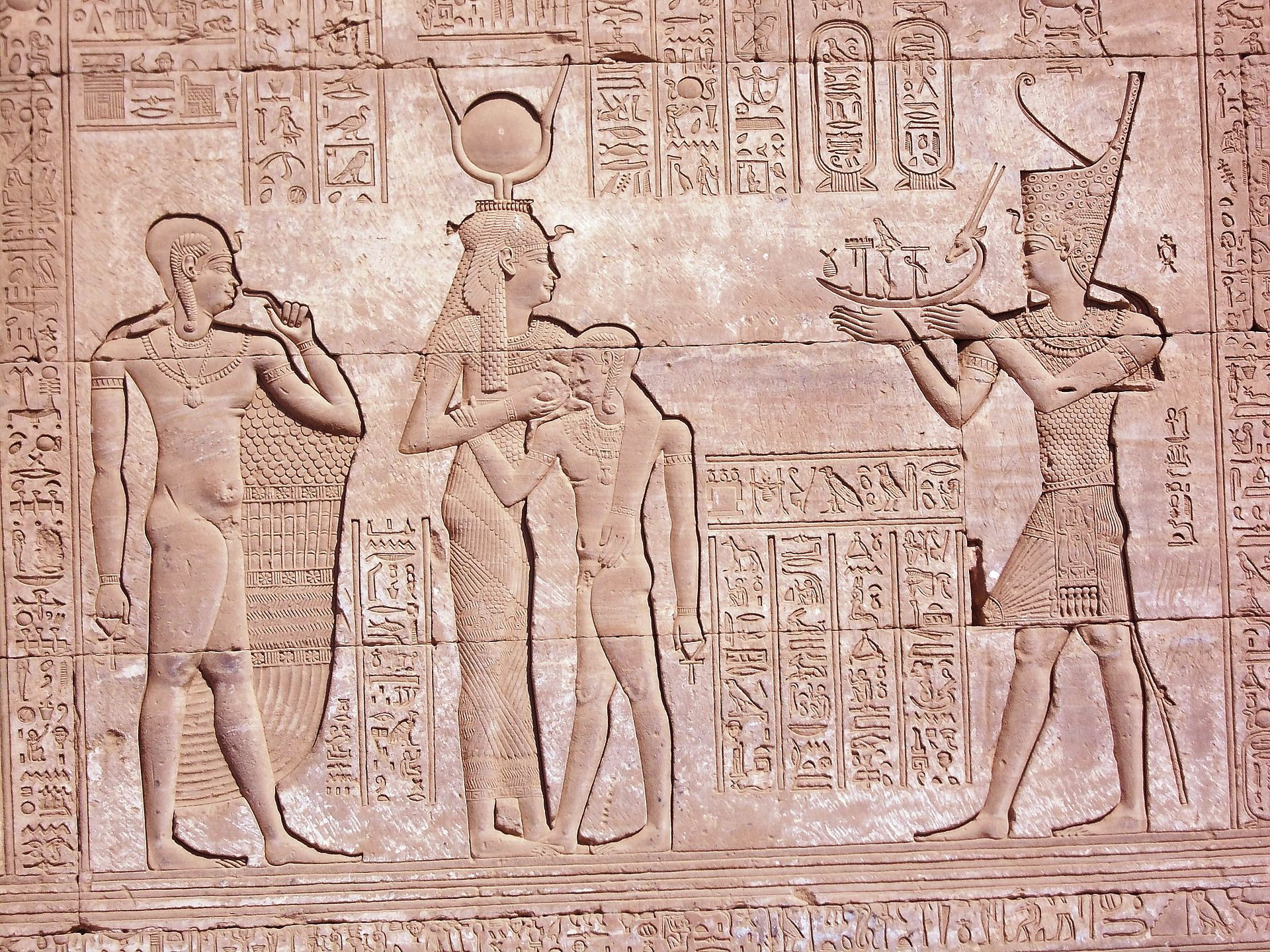 Egyptian relief at Dendera depicting Trajan in full pharaonic garb, sacrificing goods to the goddess Hathor and her son Ihy, Luxor, c. AD 98-117. Source: Wikimedia Commons