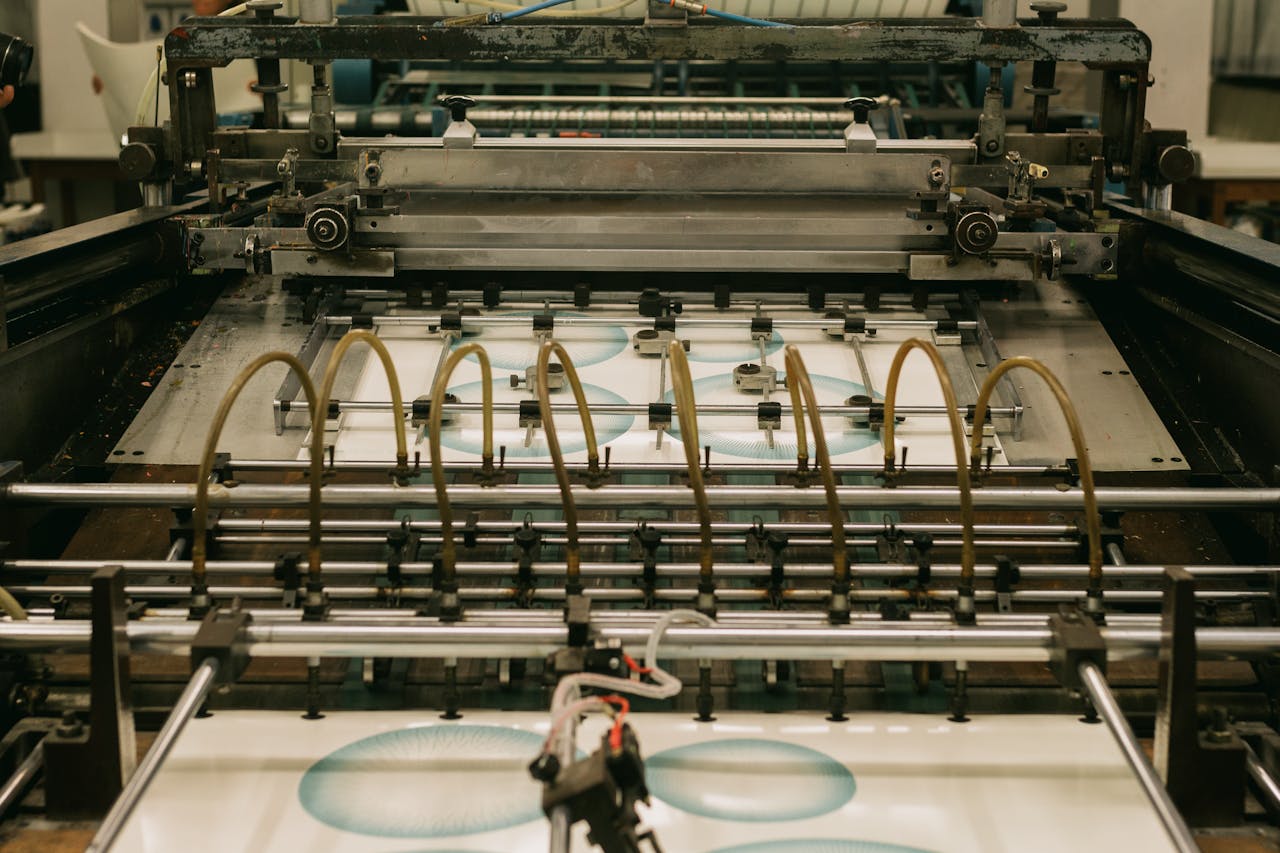 Close-up of an industrial printing press producing designs, by Joao Jesus via Pexels