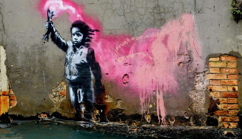 A Banksy mural, depicting a migrant child wearing a lifejacket holding a pink flare.