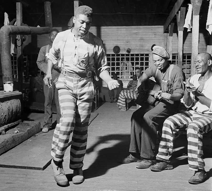 Legendary Piedmont Blues Guitarist Buddy Moss playing guitar at the Greene County Convict Camp, Georgia, Source: Wikimedia Commons