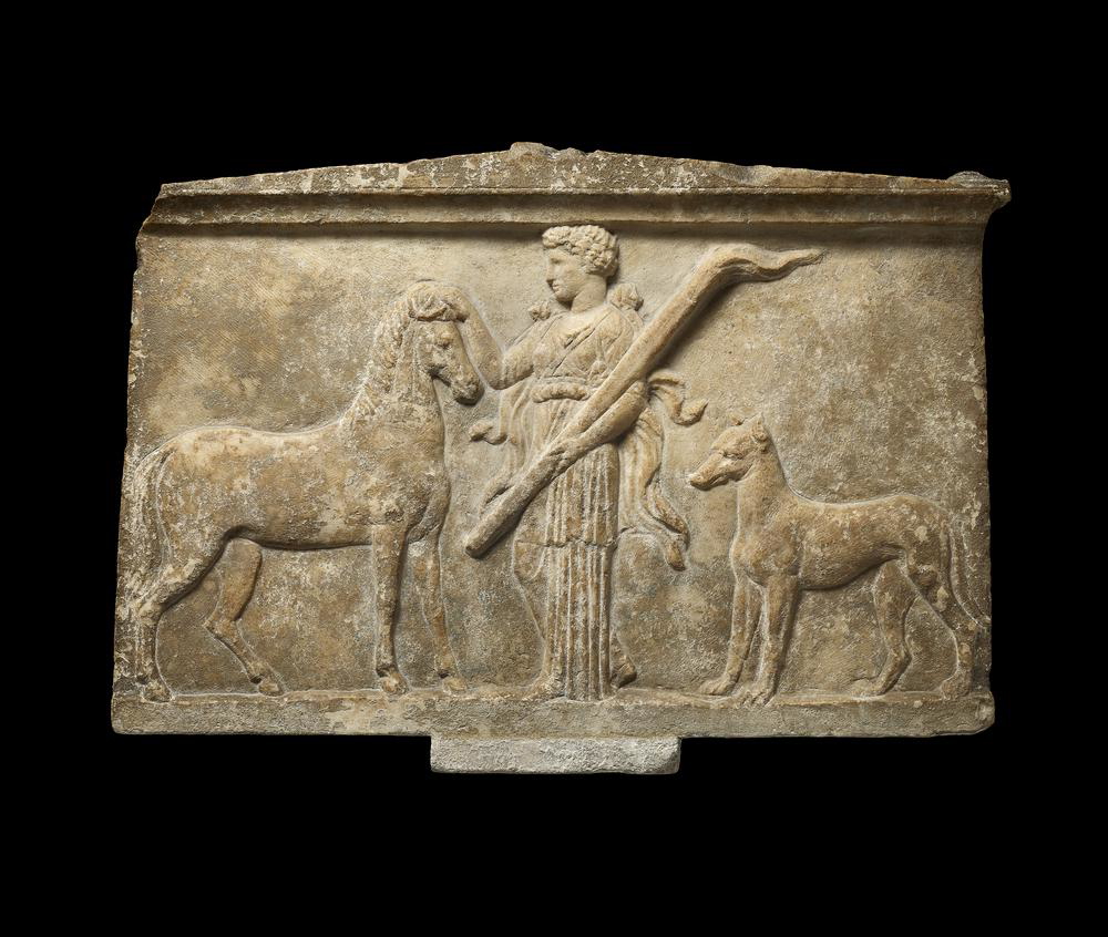 Marble votive altar showing probably Artemis or Hecate with torch flanked by a mare and a dog, Thessaly, c. 400 BCE. Source: British Museum