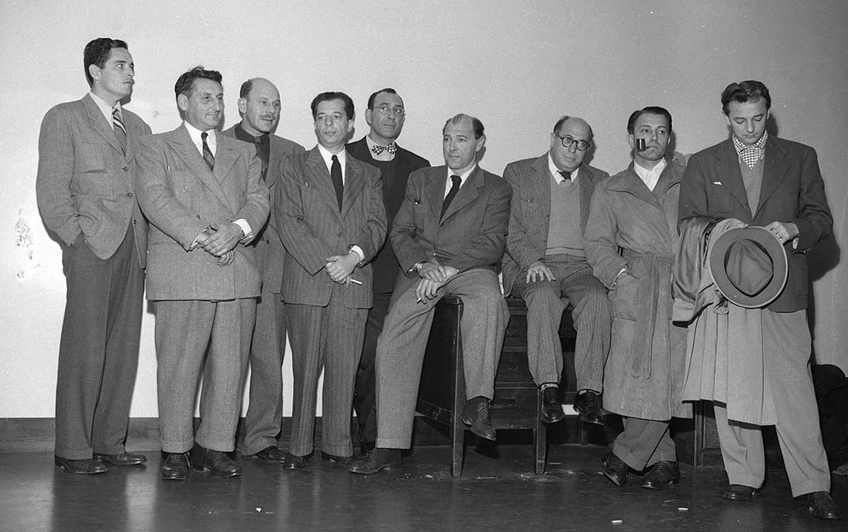 Nine of the Hollywood Ten. From right to left: Robert Adrian Scott, Edward Dmytryk, Samuel Ornitz, Lester Cole, Herbert Biberman, Albert Maltz, Alvah Bessie, John Howard Lawson, and Ring Lardner Jr – missing is Dalton Trumbo, 1947Source: Wikimedia Commons