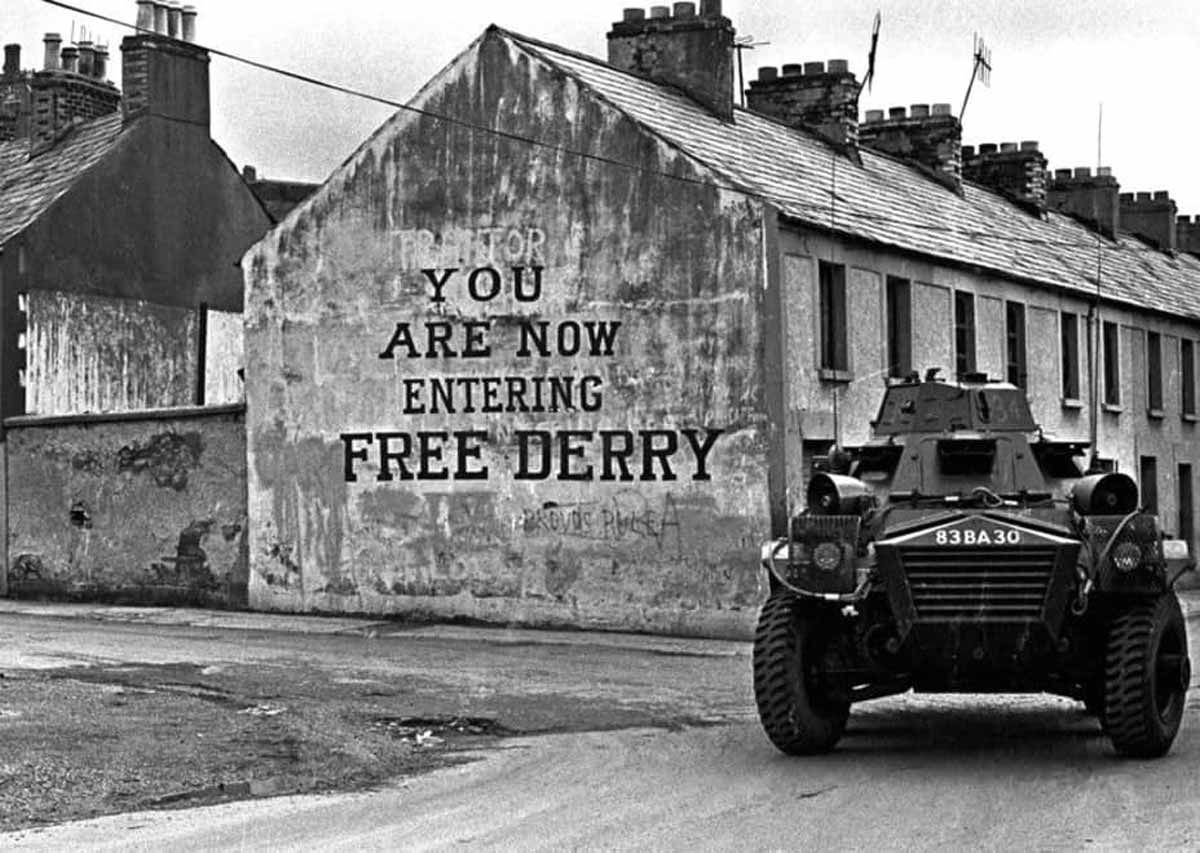 british army armored vehicle passes free derry