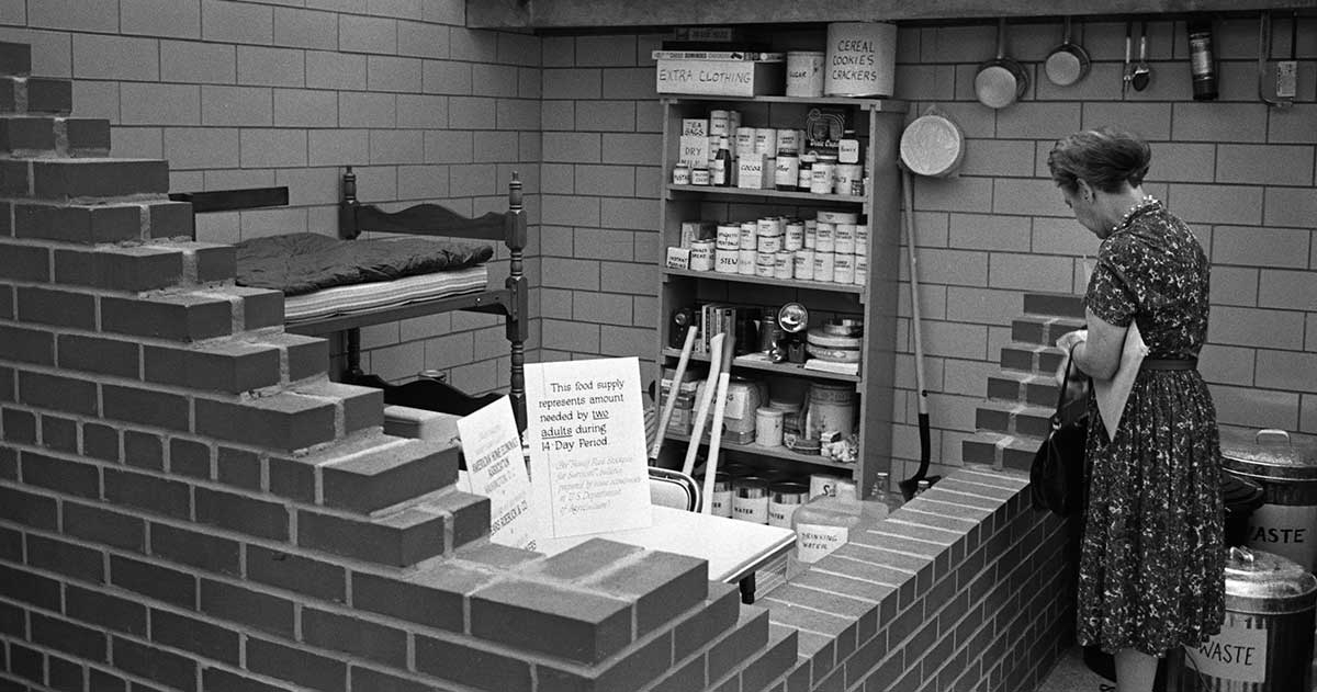woman viewing model bomb shelter food supplies 1961
