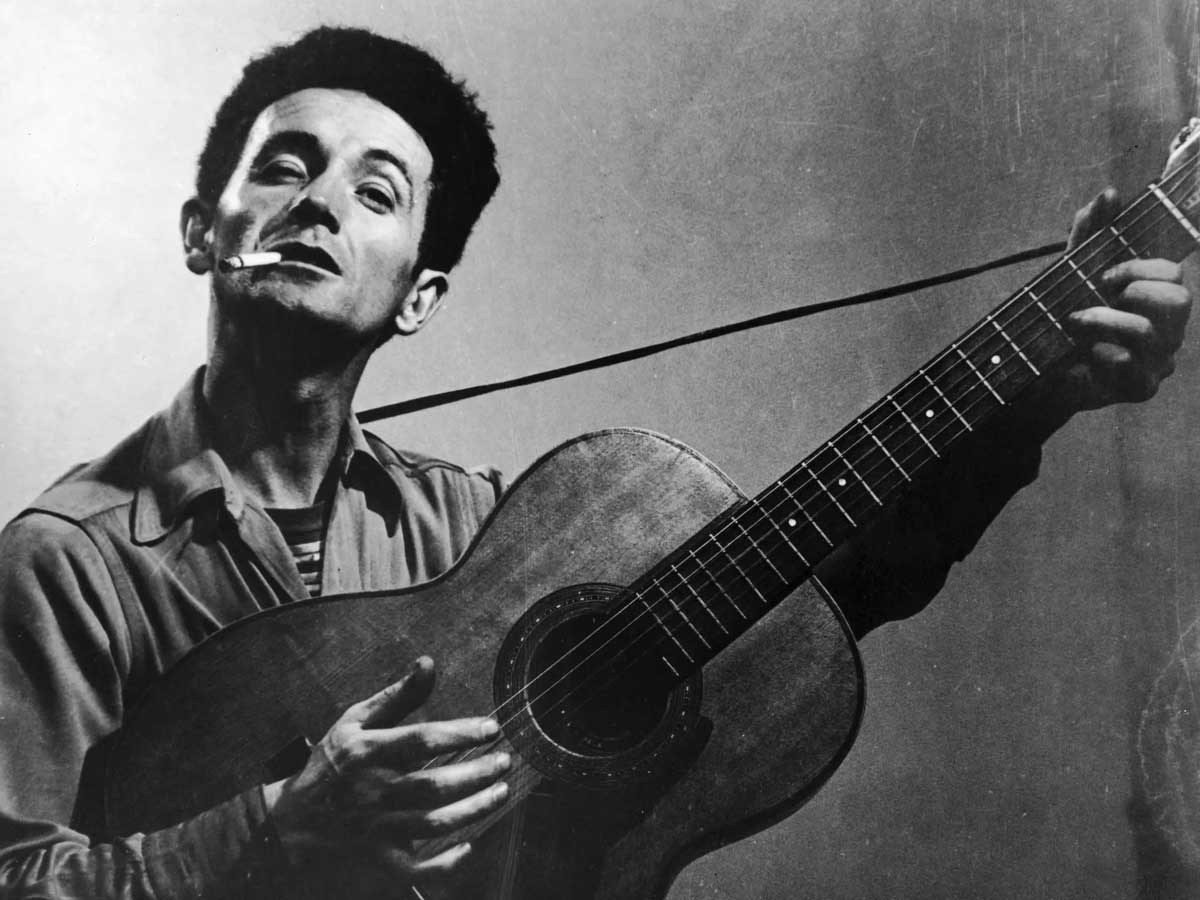 woody guthrie with guitar