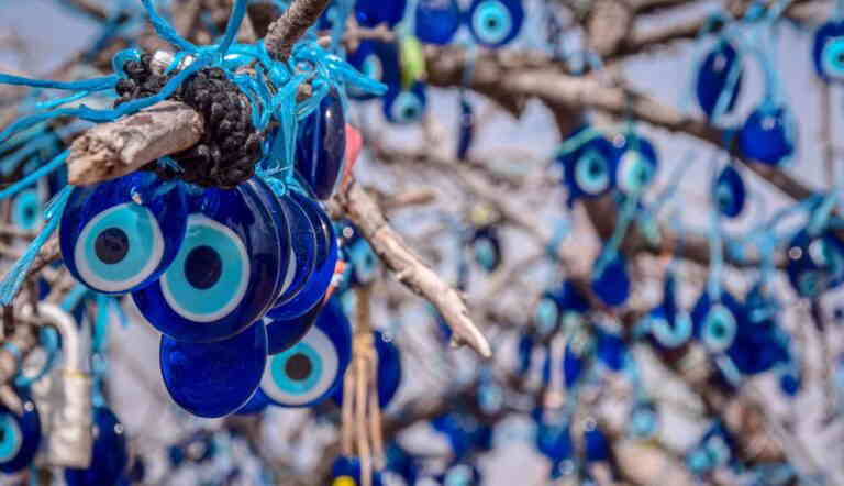 Blue evil eye charms hanging on tree