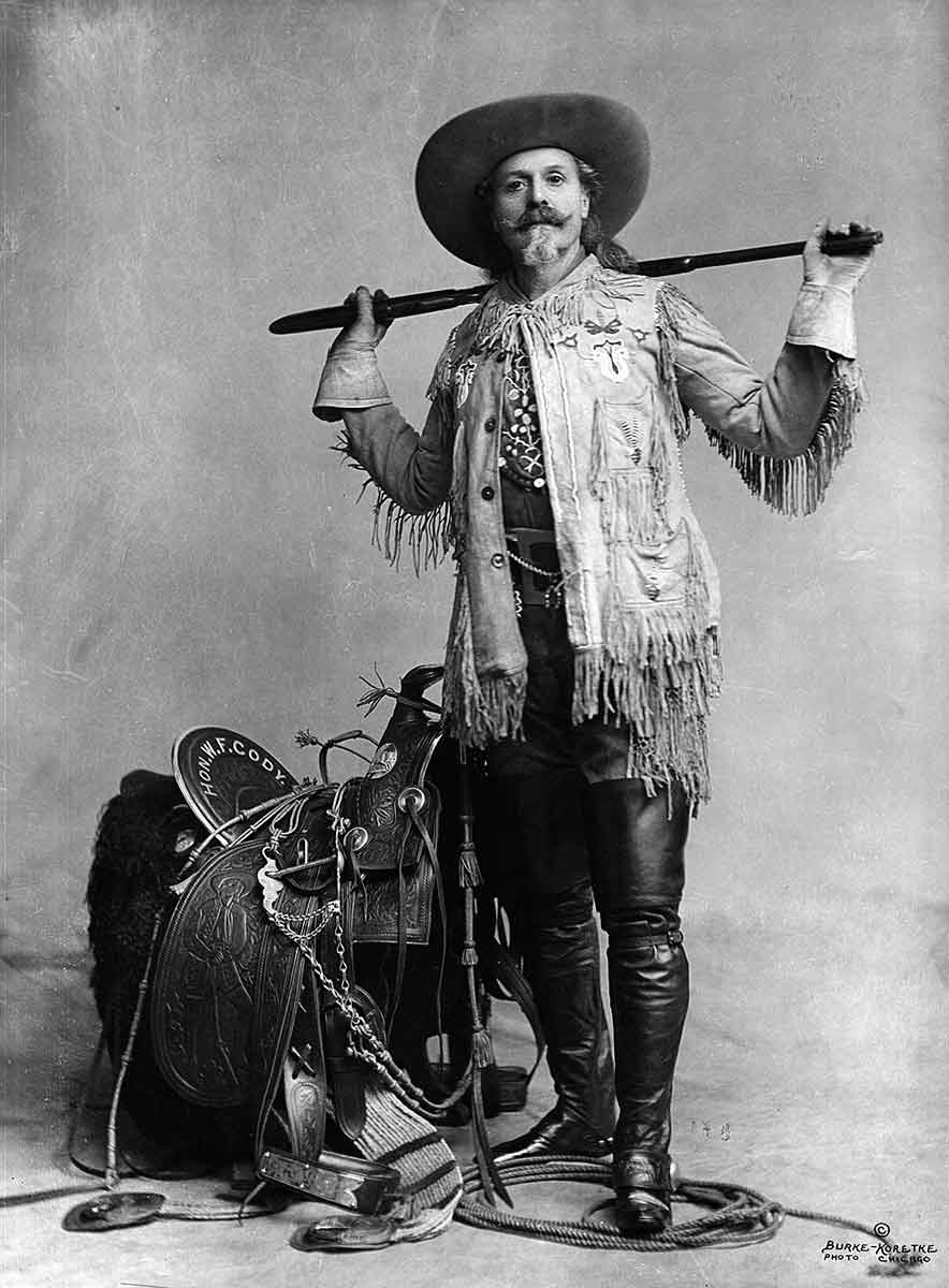 bill posing with rifle and saddle