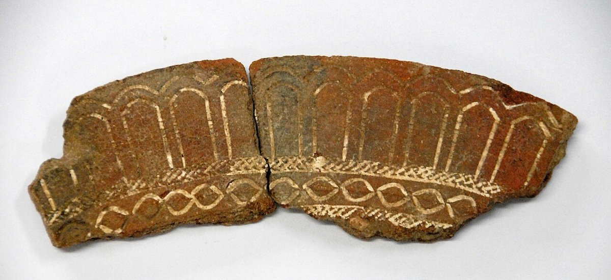 Horizontal color photo of a Lapita pottery rim sherd from Bourewa, Fiji, with dentate stamping and lime infill, c. 1000–800 BCE.