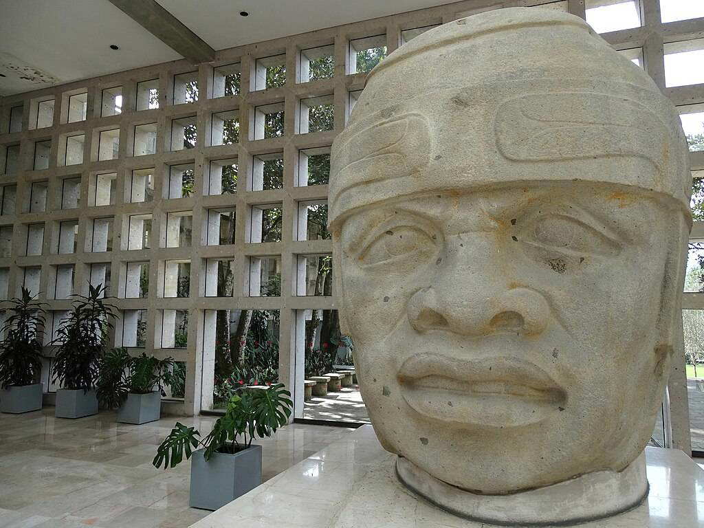 Wide exterior view of an Olmec colossal basalt head at the entrance of the Museo de Antropología de Xalapa, Veracruz, c. 900–400 BCE.