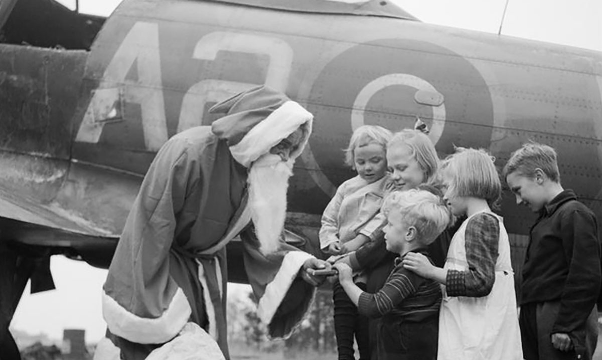 santa claus gives presents local children