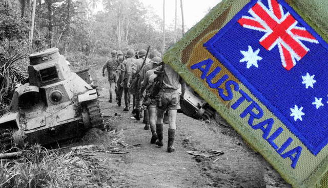 Australian troops advance past disabled tank