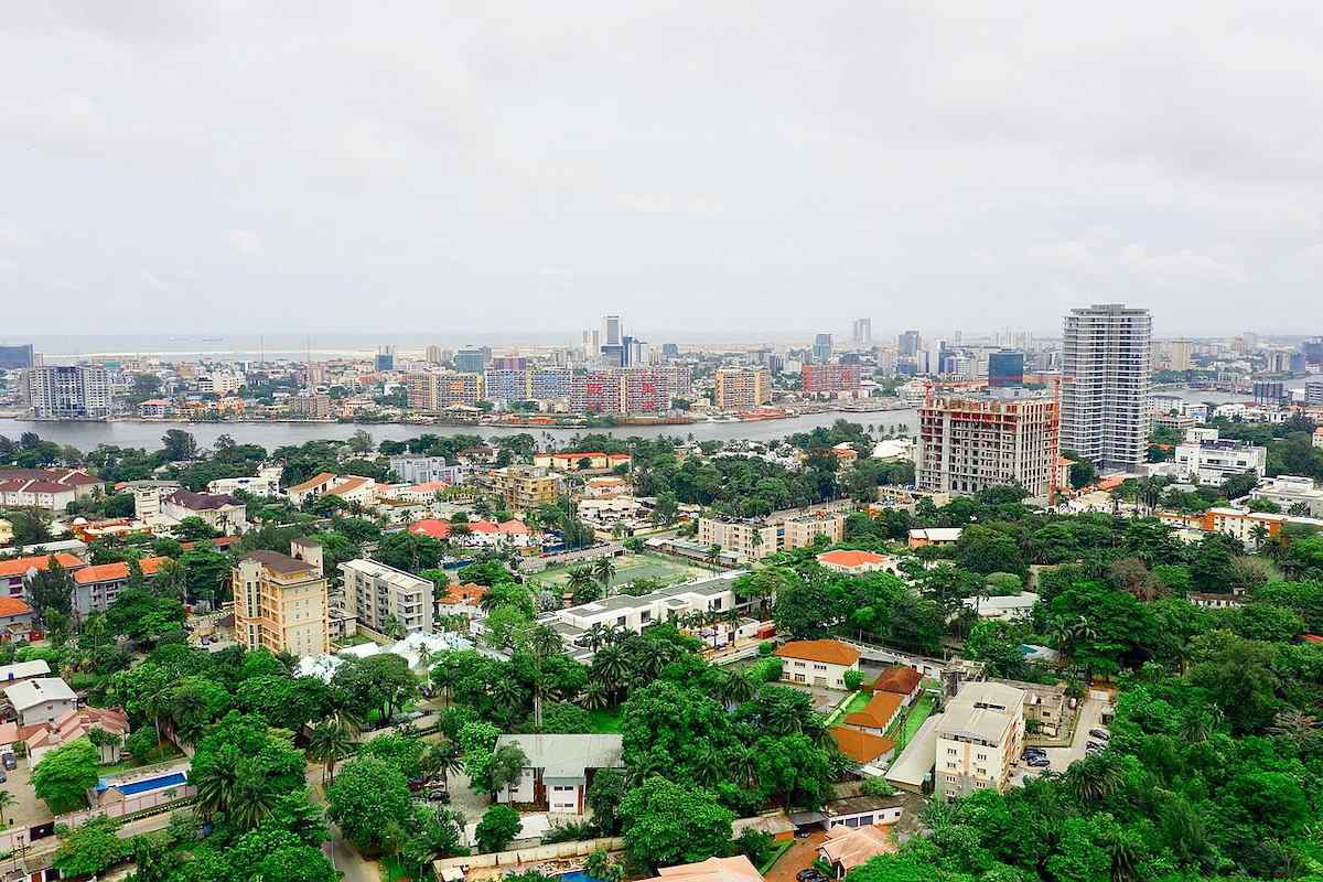 View of Lagos, Nigeria, showing modern high-rises along the waterfront under a partly cloudy sky.