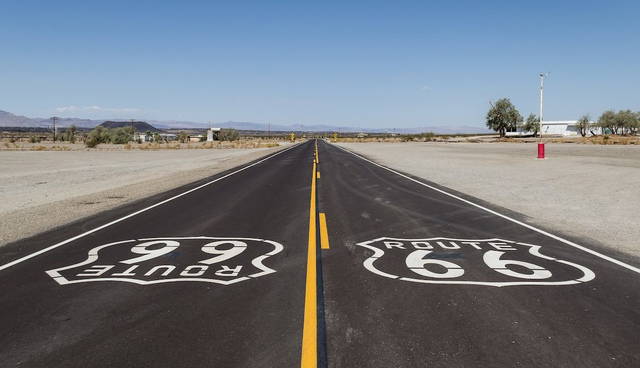 Wide view of historic Route 66 passing through Amboy, California, with Roy’s Motel and Café visible against the Mojave Desert backdrop
