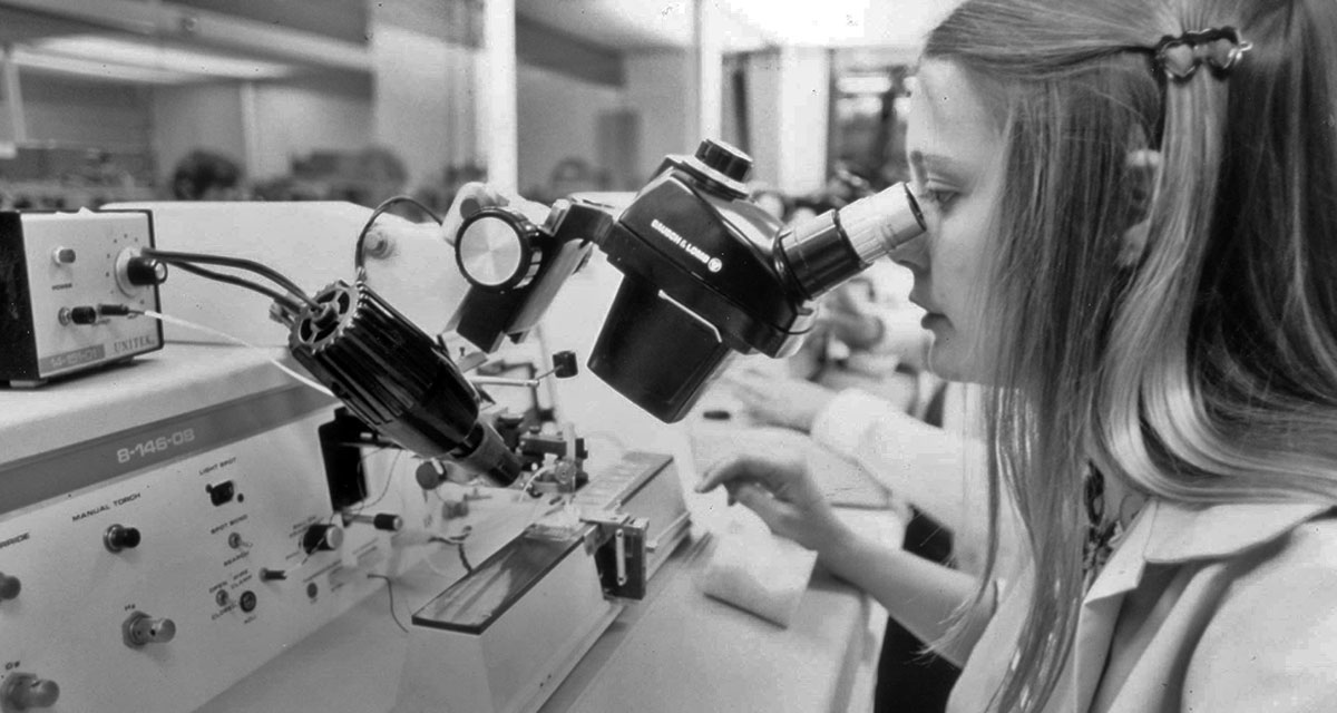 woman looking into microscope