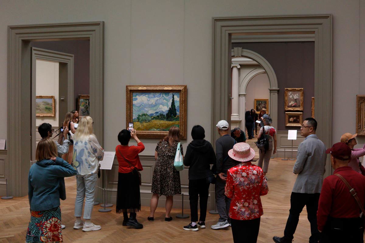 Crowd gathering in front of Van Gogh's Wheat Field with Cypresses (1889)