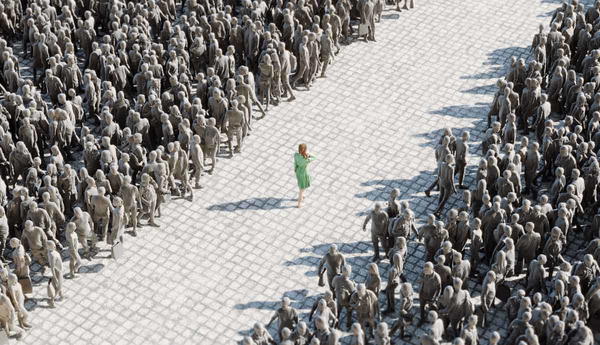 woman in green walking through grey crowd