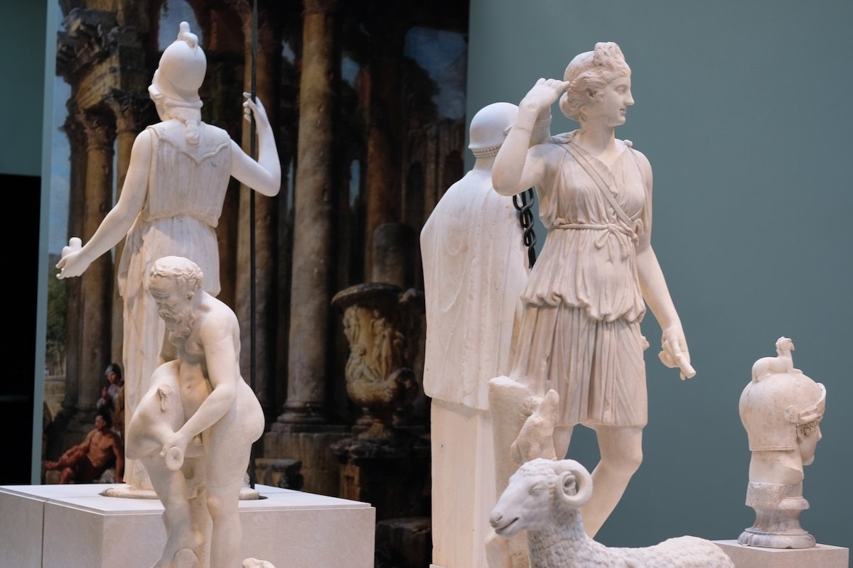 Group of marble Roman sculptures including a standing female figure, a kneeling male figure, portrait busts, and a carved ram, exhibited at the Montreal Museum of Fine Arts as part of the Torlonia Collection.
