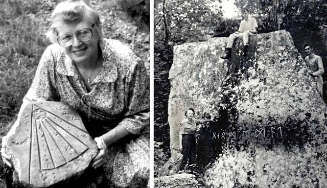 Woman holding carved stone next to runic rock.