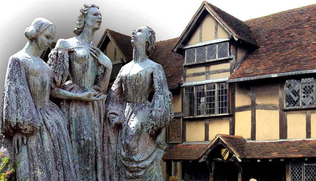 An Elizabethan building behind three bronze female statues.