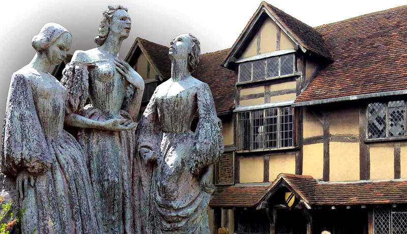 An Elizabethan building behind three bronze female statues.