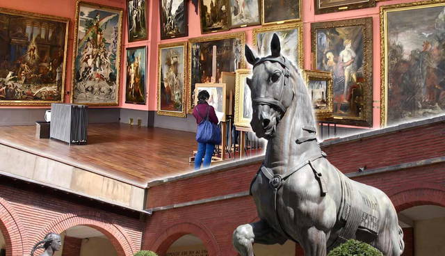 A horse statue superimposed over an art gallery interior.