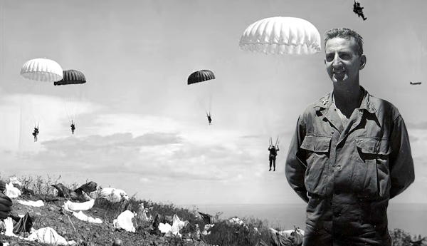 Lieutenant smiles as paratroopers land behind him.