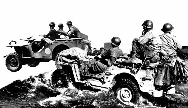 Soldiers driving two military jeeps through deep water